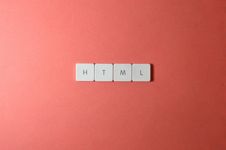 Four white tiles with black capital letters are arranged on a flat, smooth grey surface. The tiles display the letters H, T, M, and L, with the H tile positioned on the left, the T tile above, the M t